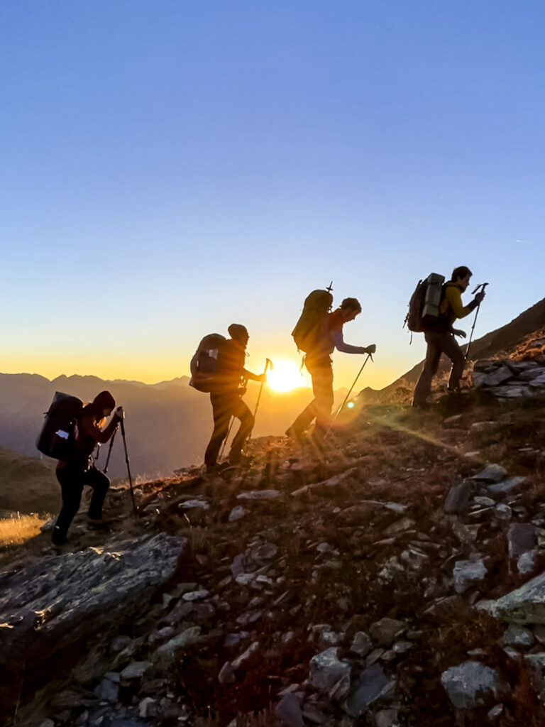 Grup de muntanya pujant a la sortida del sol